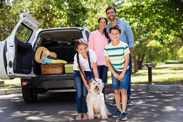 Happy family on a picnic standing next to their car — Stock Photo, Image