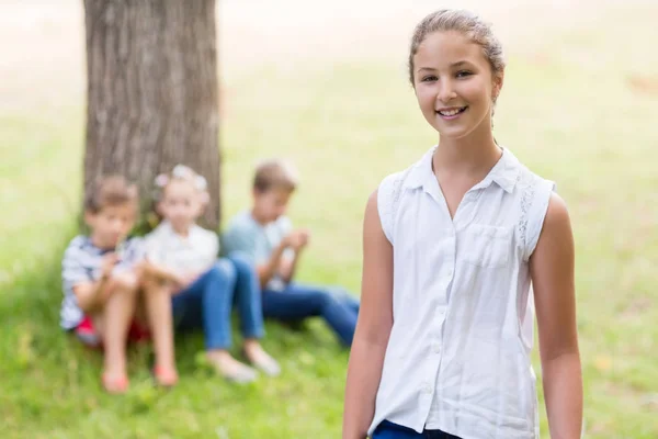 Sorridente ragazza in piedi nel parco — Foto Stock