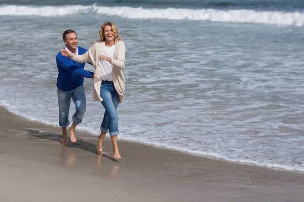 Зрелая пара наслаждается на пляже — стоковое фото