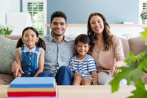 Porträtt av lyckliga föräldrar och barnen sitter på soffan i vardagsrummet — Stockfoto