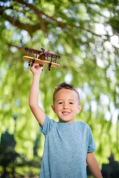 Portret van jongen speelt met een toy vliegtuig in park — Stockfoto