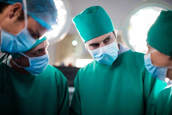 Equipe médica interagindo uns com os outros durante a realização da operação — Fotografia de Stock