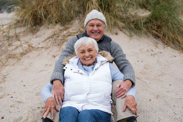 年长的夫妇一起坐在沙滩上 — 图库照片