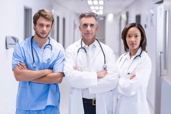 Portrait of doctors standing with arms crossed in corridor — Stock Photo, Image