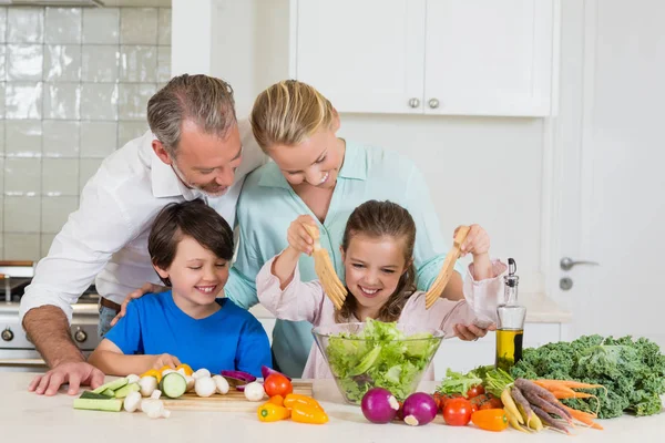 Mother and daughter preparing salad in kitchen — Stock Photo, Image