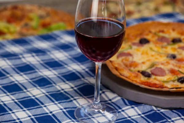 Pyszne pizzy przy lampce czerwonego wina — Zdjęcie stockowe