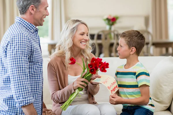 Мальчик дарит открытку и розы своей матери — стоковое фото