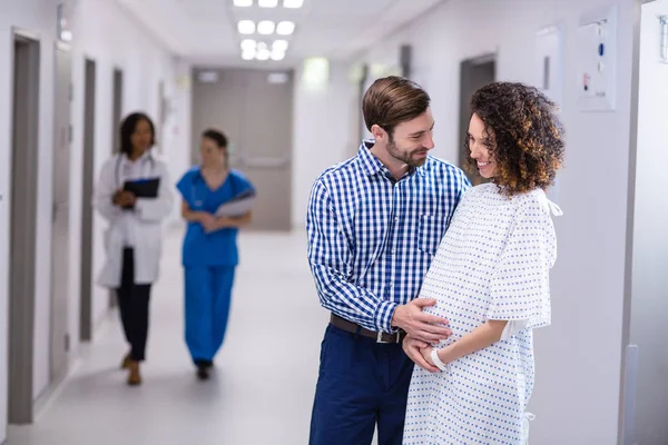 Man tröstande gravid kvinna i korridor — Stockfoto