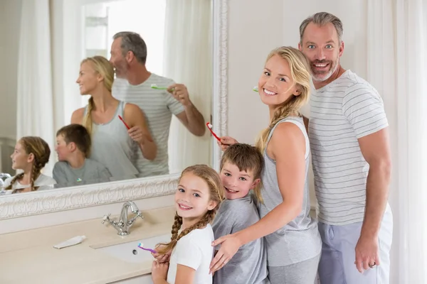 Föräldrar och barn borsta tänderna i badrum — Stockfoto