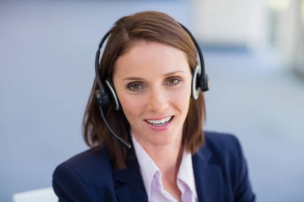 Retrato de uma mulher de negócios usando fone de ouvido — Fotografia de Stock