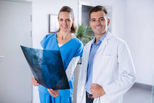 Två läkare står med i sjukhuskorridor röntgen på patienter — Stockfoto