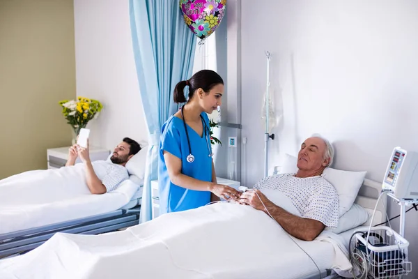 Médecin féminin interagissant avec un patient âgé masculin — Photo