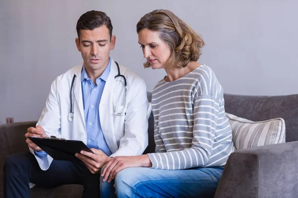 Doctor discutiendo un informe médico con la mujer —  Fotos de Stock