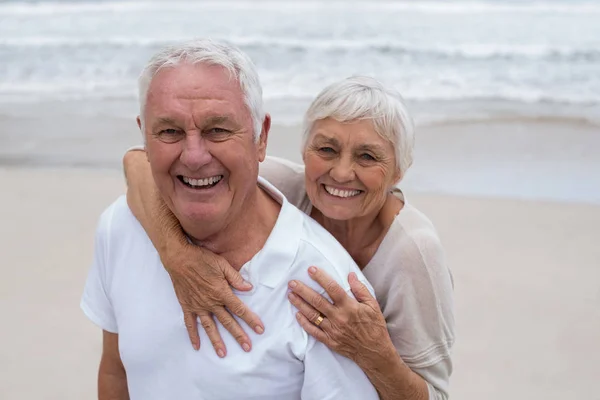 Senior paar omhelzen elkaar op het strand — Stockfoto