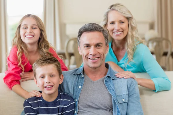 Portret van de glimlachen van ouders en kinderen in de woonkamer — Stockfoto