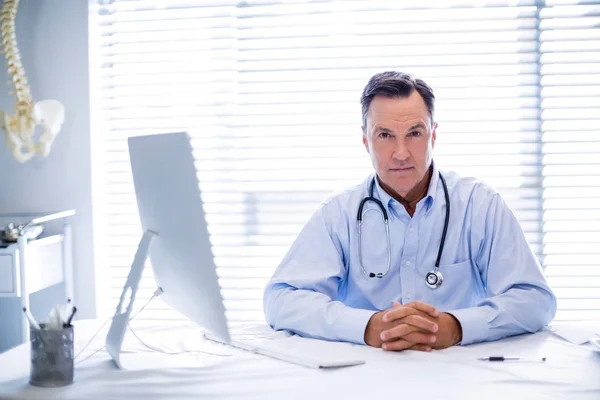 Retrato de médico do sexo masculino sentado na mesa — Fotografia de Stock