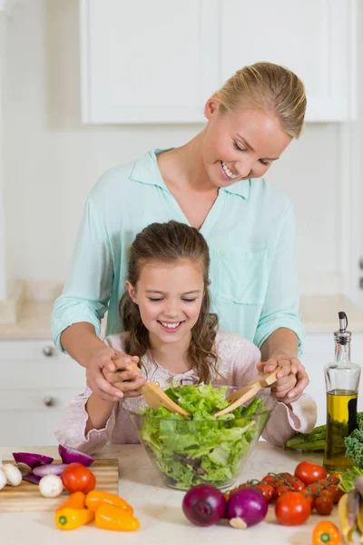 Madre e hija preparando ensalada en la cocina en casa —  Fotos de Stock