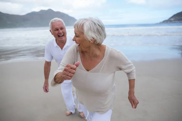 Senior para wspólna zabawa na plaży — Zdjęcie stockowe