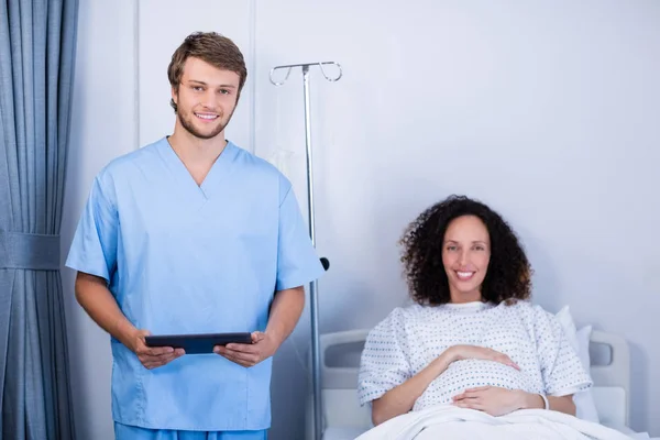 Retrato del médico sonriente y la mujer embarazada en la sala — Foto de Stock