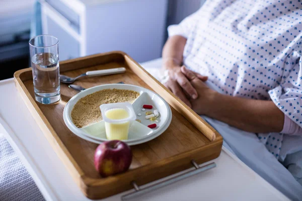 Δίσκος με μήλο και ιατρική διατηρούνται στο μέτωπο του ασθενούς — Φωτογραφία Αρχείου