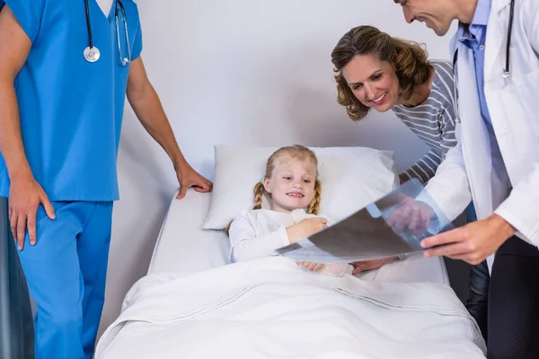 Doctors showing x-ray to patient and mother — Stock Photo, Image