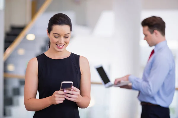 Zakenvrouw die mobiele telefoon gebruikt — Stockfoto