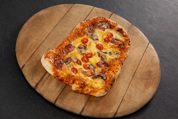 Deliciosa pizza italiana servida sobre tabla de madera — Foto de Stock