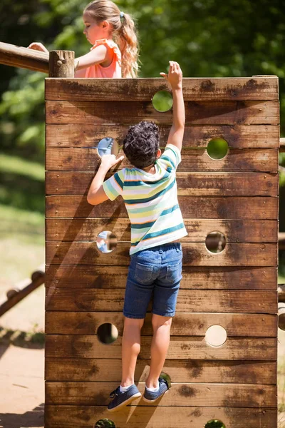 Boy climbing on a playground ride in park — Stock Photo, Image