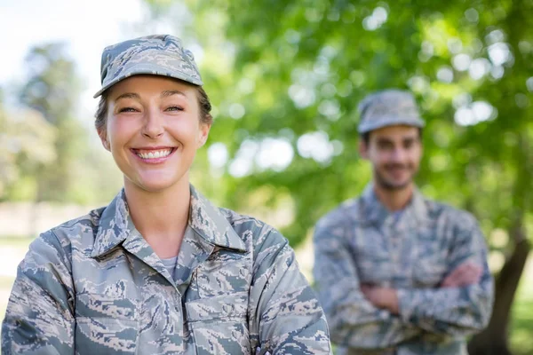 Porträt eines Militärpaares, das mit verschränkten Armen im Park steht — Stockfoto