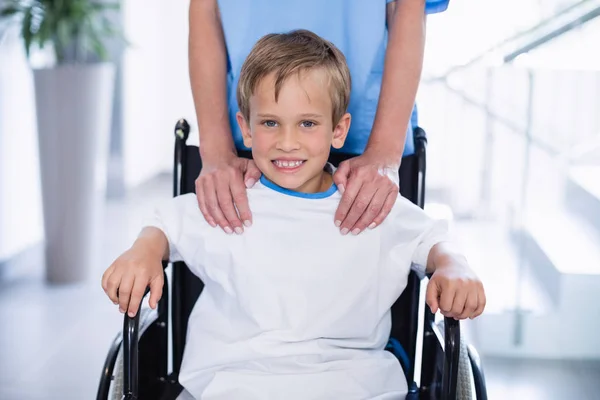 Smiling doctor showing digital tablet to disable boy — Stock Photo, Image