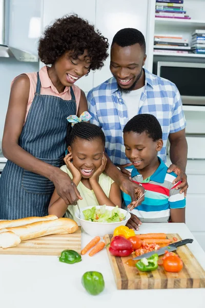 Родители и дети готовят салат на кухне — стоковое фото