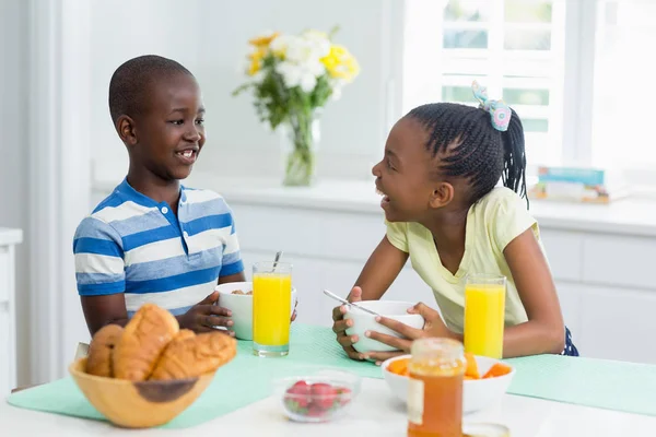 Siblings having breakfast on dining table at home — Stock Photo, Image
