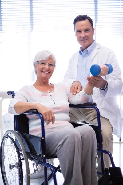 Portrait d'un physiothérapeute aidant un patient âgé à faire de l'exercice manuel — Photo