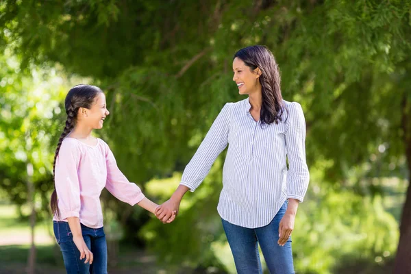 Moeder hand in hand van haar dochter in park — Stockfoto
