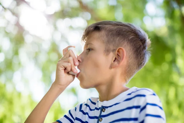 Menino usando inalador de asma no parque — Fotografia de Stock