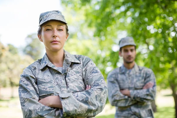 Porträt eines Militärpaares, das mit verschränkten Armen im Park steht — Stockfoto