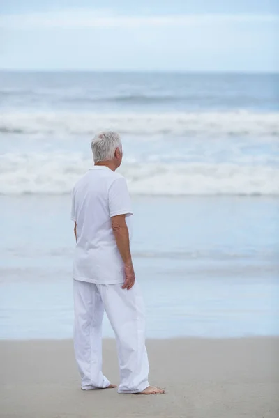 Äldre man som stod på stranden — Stockfoto