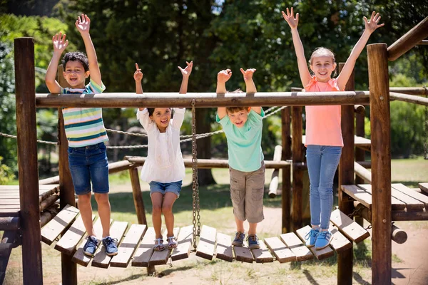 Barnen står och ler på en lekplats rida i park — Stockfoto