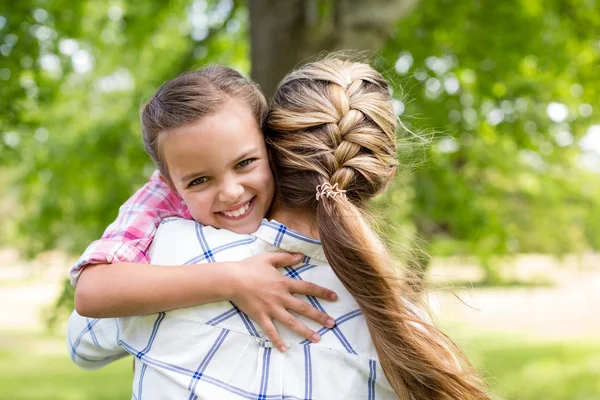 Menina abraçando sua mãe no parque — Fotografia de Stock