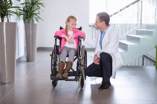 Médico sonriente hablando con chica incapacitada — Foto de Stock