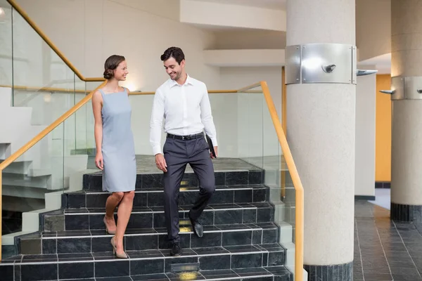 Business executives moving down steps at conference centre — Stock Photo, Image