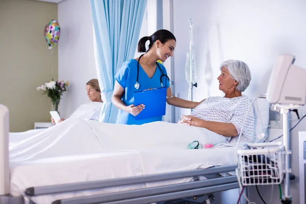 Médico femenino interactuando con paciente senior femenina —  Fotos de Stock