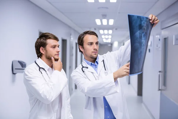 Doctors examining x-ray in corridor — Stock Photo, Image