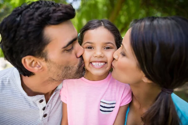 Ragazza baciata dai suoi genitori nel parco — Foto Stock