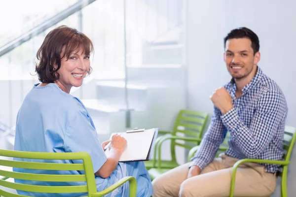 Portrait of nurse discussing a medical report with man — Stock Photo, Image