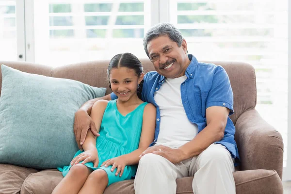 Abuelo y nieta sentados en el sofá en la sala de estar —  Fotos de Stock