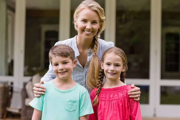 Glimlachend moeder en kinderen permanent buiten huis — Stockfoto
