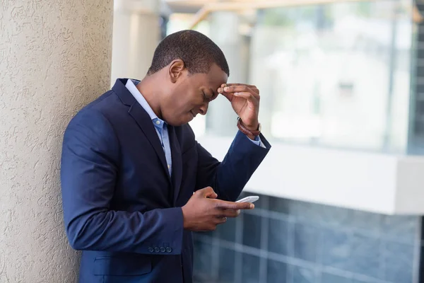 Besorgter Geschäftsmann schaut aufs Handy — Stockfoto