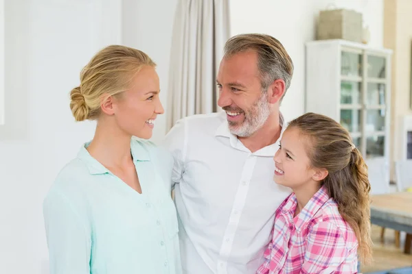 Föräldrar med dottern leende hemma — Stockfoto