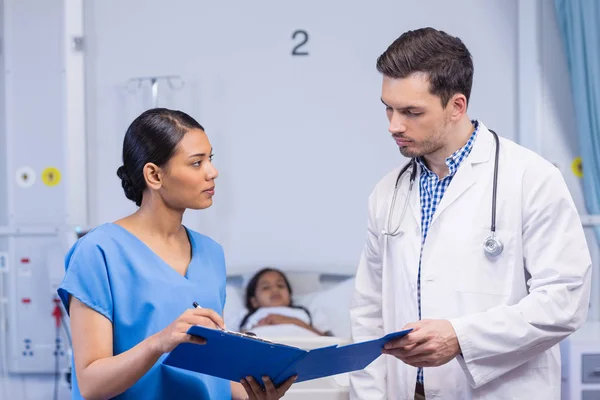 Verpleegkundige en arts bespreken over Klembord — Stockfoto